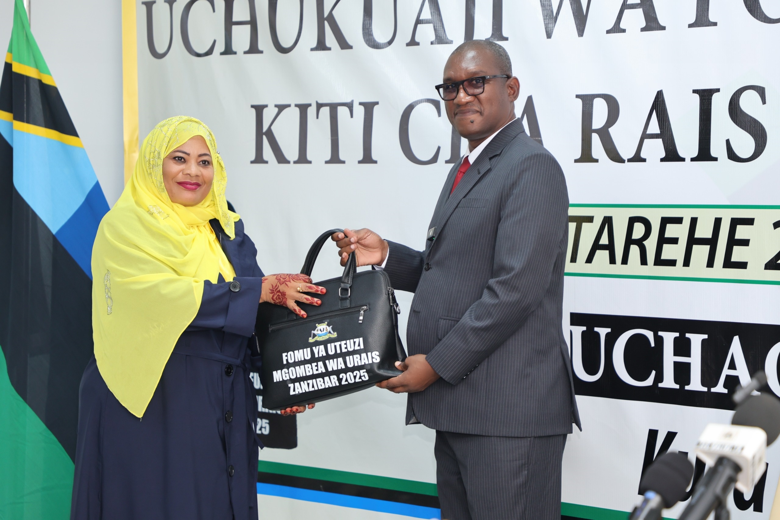 ZEC chairman Judge George Joseph Kazi pictured at the commission’s offices at Maisara in Unguja Urban District yesterday presenting nomination form to Isha Salim Hamad, the opposition Chama cha Kijamii (CCK) candidate for the Zanzibar Presidency.